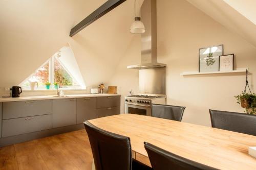 a kitchen with a wooden table and chairs and a dining room at Family villa near the IJsselmeer and forrest in Rijs