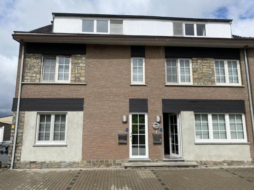a brown brick house with a white at Cozy vacation home for 8 persons in Heers in Heers