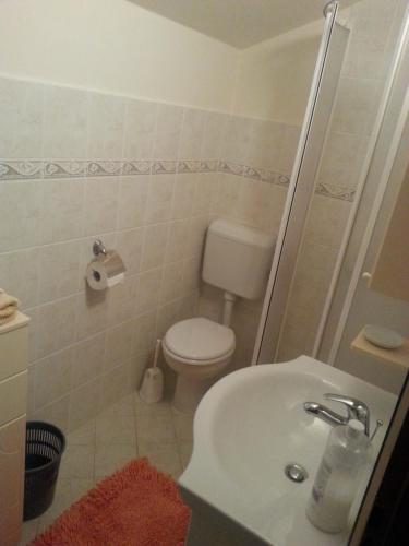 Baño blanco con aseo y lavamanos en Apartment Toni en Labin