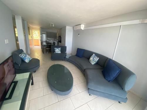 a living room with a couch and two chairs at Cozumel 320 in Umdloti
