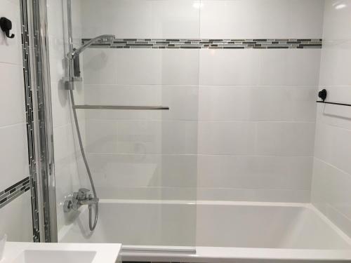 a shower with a glass door next to a sink at L auberge du lion d or in Nanteuil-sur-Marne