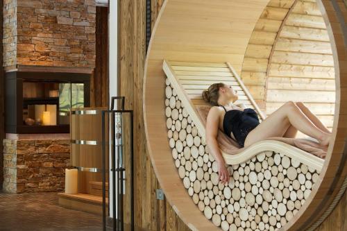 a woman sitting in a pod bed in a room at LA CHENEAUDIÈRE - Hôtel Spa - Relais & Châteaux - Restaurant étoilé in Colroy-la-Roche