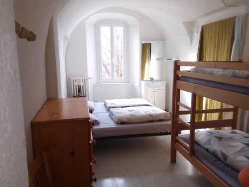 a bedroom with two bunk beds and a window at Maison familiale des Gueyniers in Jausiers