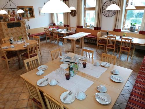 a dining room with wooden tables and chairs at Pension zum Bären in Langerringen