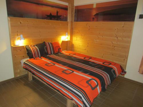 シオーフォクにあるElső Fecske apartmanokの木製の壁のドミトリールームのベッド1台分です。