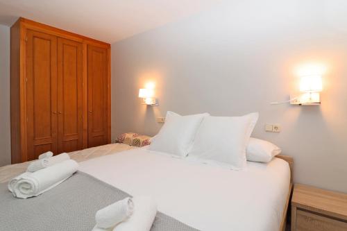 a bedroom with a white bed with two towels on it at Apartamento Besiberri Vielha in Vielha