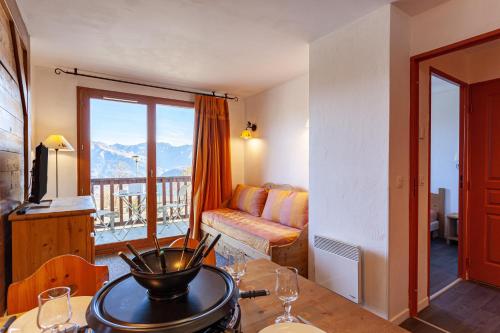 - un salon avec un canapé et une table avec des verres à vin dans l'établissement Les Alpages du Corbier A003, au Corbier