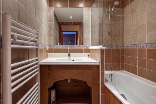 Les Alpages du Corbier A003 في لي كوربيه: حمام مع حوض وحوض استحمام