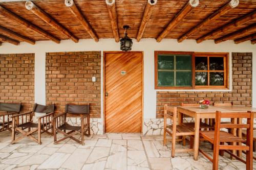 a patio with a wooden door and chairs and a table at Hotel Culturpisco in Ica