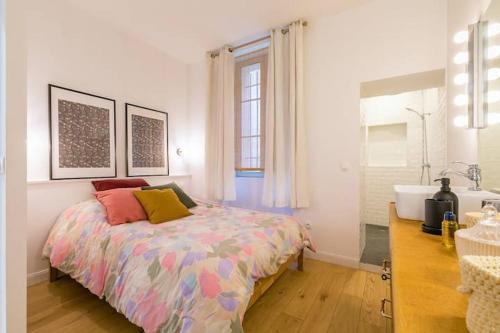 ein Schlafzimmer mit einem Bett und ein Badezimmer mit einer Badewanne in der Unterkunft le Tillot in Dijon