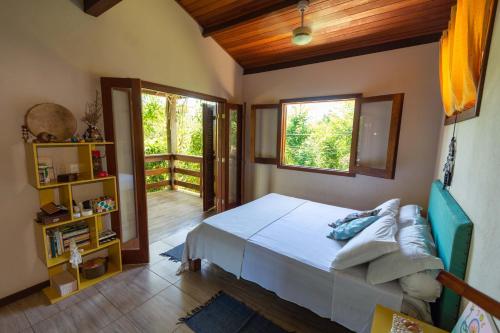 インバサイにあるCasa Raízes Imbassaiのベッドとバルコニーのある寝室
