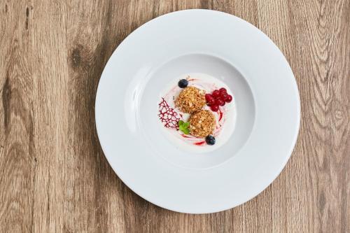 a white plate with dessert on a wooden table at Chalets Franciska Major, Pro Village in Sopronkövesd