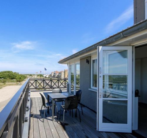 a patio with a table and chairs on a deck at Apartment Aalscholver (4P) - Residence Kabbelaarsbank in Ouddorp