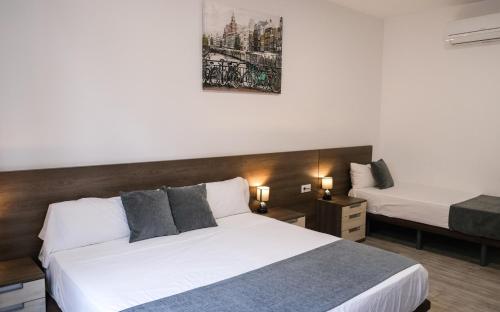 una camera d'albergo con due letti e due lampade di Hostal Tartessos a Valencia