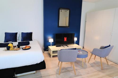 - une chambre avec un lit, une télévision et des chaises dans l'établissement Studio SAINT-VINCENT 150M DU PORT, à Vannes