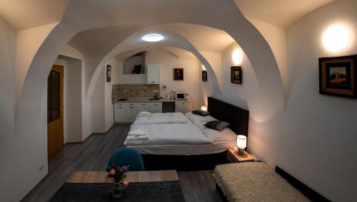 sypialnia z dużym łóżkiem w sklepionym pokoju w obiekcie Penzion U Hejtmana w mieście Klatovy