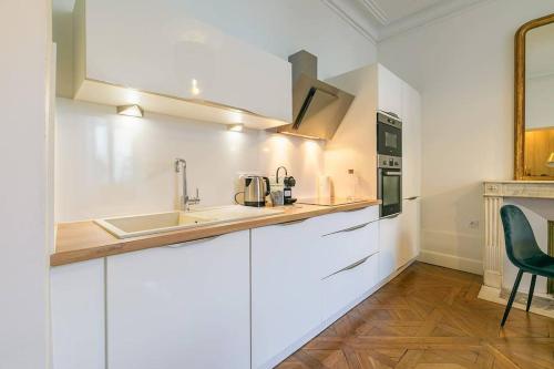 une cuisine blanche avec un évier et un micro-ondes dans l'établissement La Closerie des Cordeliers, à Dijon