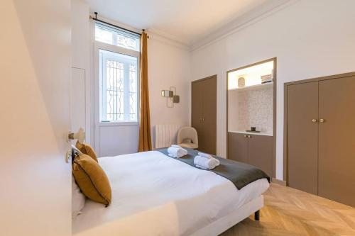 une chambre avec un grand lit blanc et une fenêtre dans l'établissement La Closerie des Cordeliers, à Dijon