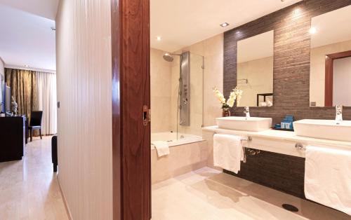 a bathroom with two sinks and a large mirror at Oh Nice Ulises Ceuta in Ceuta