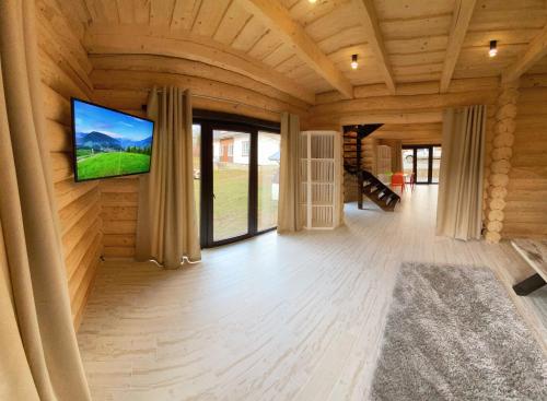 a large room with a flat screen tv on a wooden wall at Guculka Apartments in Yaremche