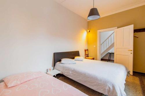 a bedroom with a bed with a white bedspread at Villa de Daelhoeve luxurious with big garden in Heers