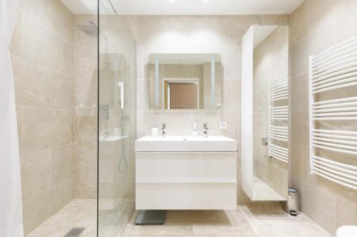 une salle de bain blanche avec un lavabo et une douche dans l'établissement Carlton area XXL luxe 1 bed with large terrace, à Cannes