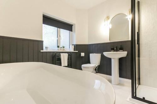 a bathroom with a tub and a sink and a toilet at Hareshaw House in Bellingham