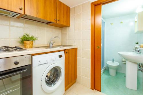 a kitchen with a washing machine and a sink at Appartamento Rosa Blu PT - MyHo Casa in Torre Canne