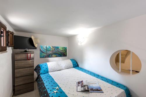 a small bedroom with a blue bed in a room at Appartamento Rosa Blu PT - MyHo Casa in Torre Canne
