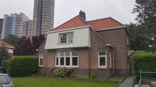 a brown house with a white roof in a city at Studio Badstrand in Vlissingen