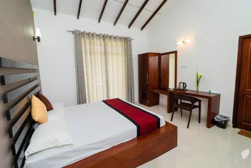 a bedroom with a bed with a desk and a window at Monaara Leisure - NuwaraEliya in Nuwara Eliya