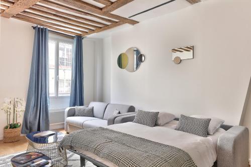 un salon avec un lit et un canapé dans l'établissement 96 - Urban Musée du Louvre, à Paris