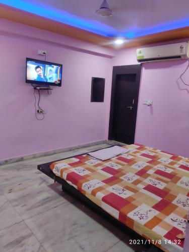 a bedroom with a bed and a tv on a wall at Hotel Thakur Shri in Bhopal