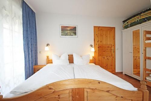 una camera da letto con un grande letto con lenzuola bianche di Ostseetraum Wohnung EG a Wittenbeck