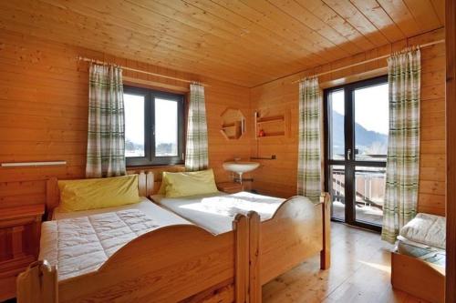 a bedroom with a large bed in a wooden cabin at Haus Gerdi in Söll