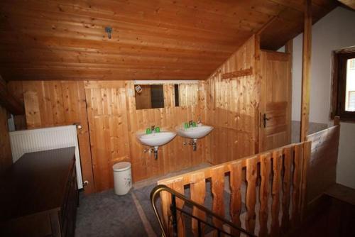 a bathroom with two sinks on a wooden wall at Haus Gerdi in Söll