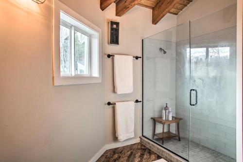 a bathroom with a glass shower with a window at Lakefront Retreat with Hot Tub about 7 Mi to Schweitzer! in Sagle