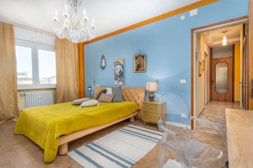 - une chambre avec un lit jaune et un mur bleu dans l'établissement Lucilla Home - APT con WiFi nel cuore di Udine, à Udine