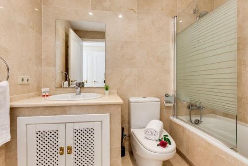 łazienka z toaletą, umywalką i wanną w obiekcie Roda Golf Resort FIT FOX w Murcji