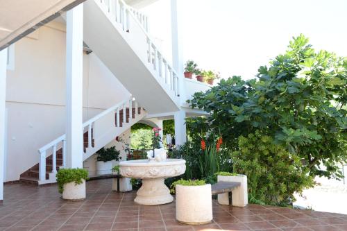 a building with a fountain and stairs with plants at Apartments Vila Lazarevic in Tivat