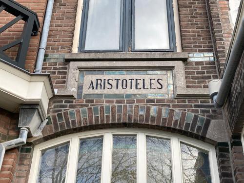 a sign on the side of a brick building at Aristoteles Apartments in Scheveningen