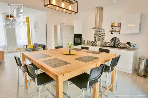 Il comprend une cuisine et une salle à manger avec une table et des chaises en bois. dans l'établissement Villa des Ursulines, à Valenciennes