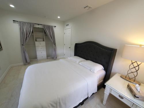 Un dormitorio con una gran cama blanca y una mesa en Miami-Airport Oasis VIP House, en Miami