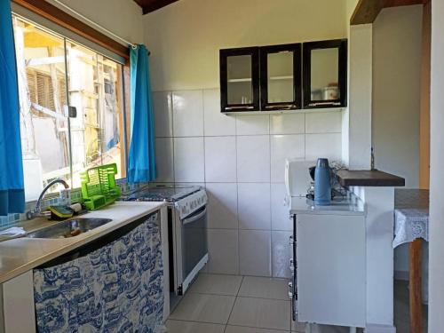 Casa em Ilhabela SP في إلهابيلا: مطبخ مع مغسلة وموقد