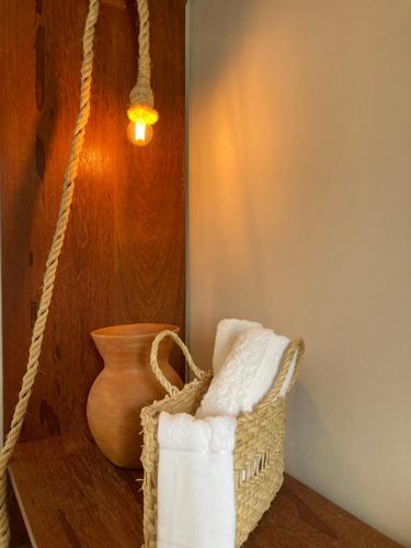 a basket with towels and a vase on a table at Trancoso Suíte Center Braga in Trancoso
