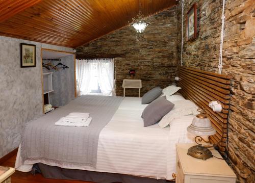 a bedroom with a large bed in a brick wall at CASA SAVIOR in Lourenzá