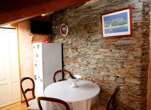 eine Küche mit einem Tisch und einem weißen Kühlschrank in der Unterkunft CASA SAVIOR in Lourenzá