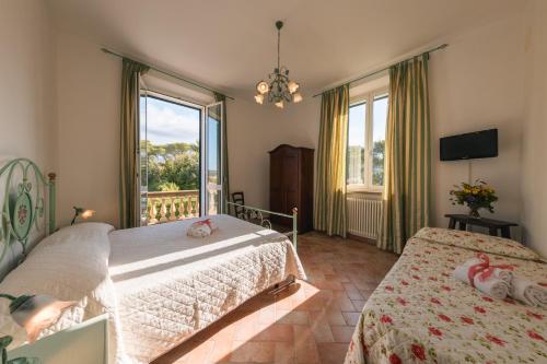 sypialnia z 2 łóżkami i dużym oknem w obiekcie Villa Toscana Irene w mieście Pomaia