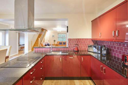 uma cozinha com armários vermelhos e azulejos vermelhos em Host & Stay - Holmedene em Filey