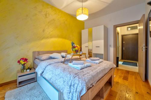 a bedroom with a large bed and a yellow wall at Apartments Mons in Vila Katalina in Zlatibor